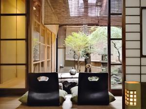deux chaises noires dans une pièce avec une fenêtre dans l'établissement 慶有魚·老松(Kyotofish·Oimatsu)*百年松树町屋*京都繁华地带*近皇宫鸭川*民宿认证, à Kyoto