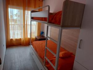 1 dormitorio con litera y almohada naranja en BRAVAHOLIDAYS-282-Palmeras-2, en Blanes