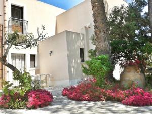 a building with pink flowers in front of a building at Casolare Nelle Saline in Torre Nubia