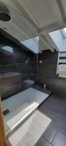 Łazienka z prysznicem i wanną ze szklanymi drzwiami w obiekcie Chambre d'hôtes avec piscine au calme dans maison Basque w mieście Ascain +6 zdjęć