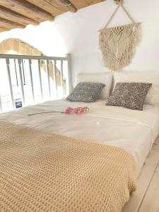 a white bed with flowers on it in a room at Anemone traditional house in Lartos