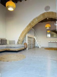 un grand salon avec un canapé et un escalier dans l'établissement Anemone traditional house, à Lardos