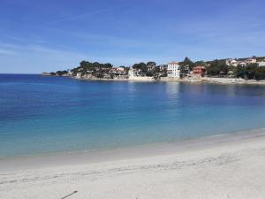 a view of a beach with houses in the distance at L'Escale Marine : Centre ville/ Plage in Bandol