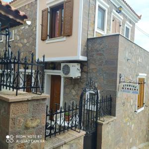 a house with a gate in front of a building at Mpaliaka Myrsini in Mythimna