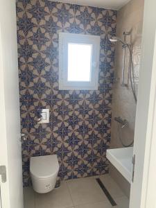 a bathroom with a toilet and a window at Charmant logement front port et Mer in Port El Kantaoui