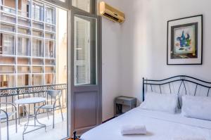 a bedroom with a bed and a balcony with a table at Dioskouros Hostel in Athens