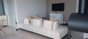 a living room with a white couch with pillows at Casa Veronica in Manerba del Garda