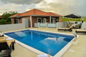 a swimming pool in front of a house at VILLA REBECCA, Muć - Split in Gornji Muć