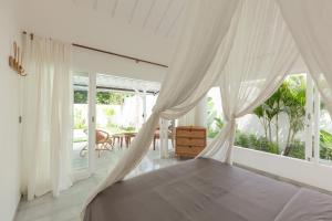 a bedroom with a canopy bed and a patio at The Bingin Beach Villas' Private Villas in Uluwatu +102 photos