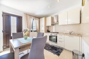 cocina con mesa de madera y sillas en Ana, en Baška