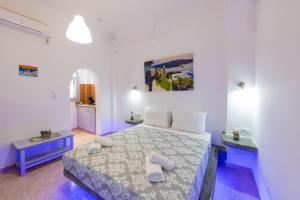 a bedroom with a bed with two towels on it at SantoriniNY in Perissa