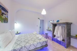 a bedroom with a large bed and a mirror at SantoriniNY in Perissa