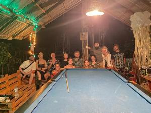 a group of people standing around a pool table at Tree house Hostel Sigiriya in Sigiriya