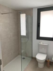 a bathroom with a toilet and a glass shower at Appartement Casares - Mer, Golf, Piscine, Padel - FINCA CORTESIN in Estepona