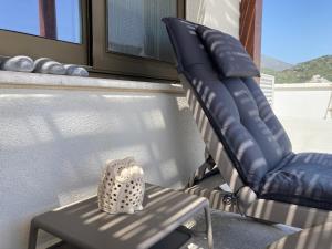 a chair and a vase on a table on a balcony at Lilian Loft Sea View - Adults Only in Plakias
