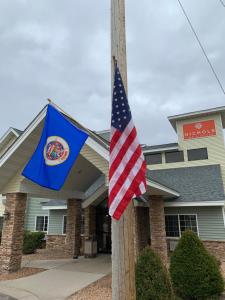 una bandera en un poste junto a una bandera de nosotros en Nichols Inn of Red Wing, en Red Wing