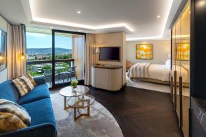 a hotel room with a blue couch and a bed at FIVE Zurich - Luxury City Resort in Zürich
