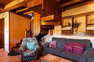 ein Wohnzimmer mit einem Sofa und einem Stuhl in der Unterkunft Casa La Fuente Vibaño in La Sestal