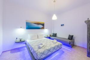 a bedroom with a bed and a couch at SantoriniNY in Perissa