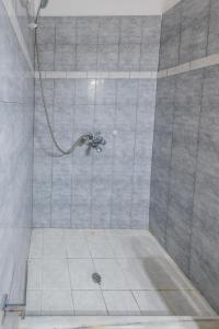 a bathroom with a shower with a tile floor at SantoriniNY in Perissa