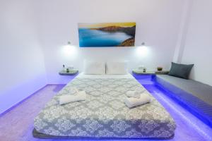a bedroom with a bed with two pillows on it at SantoriniNY in Perissa
