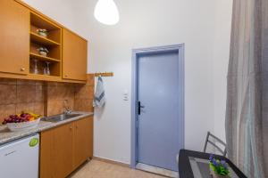 a kitchen with a door leading to a sink at SantoriniNY in Perissa