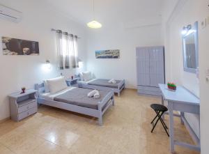 a living room with a bed and a desk at SantoriniNY in Perissa