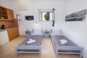 a room with two beds and a kitchen at SantoriniNY in Perissa