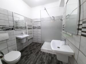 a white bathroom with two sinks and a toilet at Four Rooms Apartment Central in Bucharest