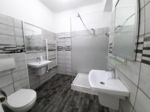Baño blanco con 2 lavabos y aseo en Four Rooms Apartment Central, en Bucarest