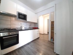 Una cocina con gabinetes blancos y un horno de estufa. en Four Rooms Apartment Central, en Bucarest