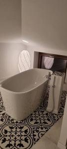 een badkamer met een wit bad en een tegelvloer bij CANNUBI SAN LORENZO,Mansarda in Barolo