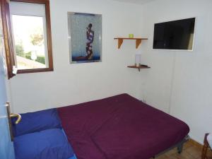 マルセイヤンにあるAppartement Marseillan-Plage, 3 pièces, 6 personnes - FR-1-387-78の紫色のベッドと窓が備わる客室です。