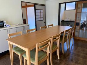 una mesa de madera y sillas en la cocina en 九右衛門ゲストハウス(kuemon guesthouse), en Noroshi