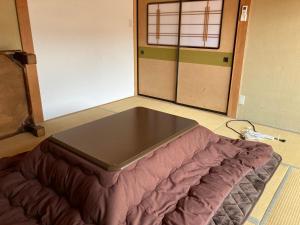 1 cama en el suelo en una habitación en 九右衛門ゲストハウス(kuemon guesthouse), en Noroshi