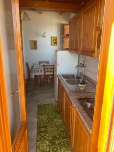una piccola cucina con lavandino e tavolo di Appartamenti Casa Conte a Ischia