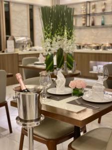 a table in a restaurant with plates and glasses at Central Park Saigon Hotel in Ho Chi Minh City