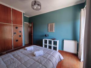 a bedroom with a large bed and a blue wall at Sea & Sun - 4th floor comfy apartment, great view in Preveza