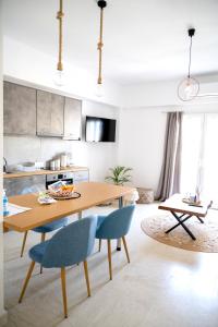 cocina con mesa de madera y sillas azules en Atop gold luxury suites, en Ermoupoli