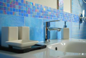 a bathroom with a sink and a blue tiled wall at La Vispa Teresa in Ischia