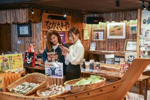 two women standing in a store looking at a cell phone at Aso Hotel in Aso +67 photos