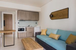 a living room with a blue couch and a kitchen at Passenger in Alexandroupoli