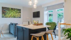 a kitchen with a blue island with stools at Hillside Haven, panoramic views Nr Bakewell in Great Rowsley