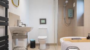 a bathroom with a sink and a toilet and a bath tub at Hillside Haven, panoramic views Nr Bakewell in Great Rowsley +19 photos