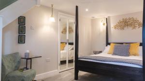 a bedroom with a bed and a mirror at Hillside Haven, panoramic views Nr Bakewell in Great Rowsley