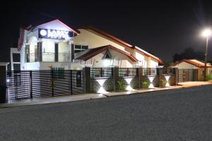 a white building with a sign on it at night at Labev Hotel in Kumasi