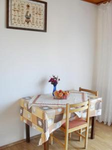 a table and chairs with a bowl of fruit on it at Apartment Bella Vista in Prožura