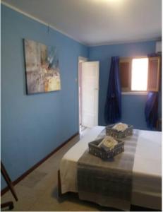 a blue bedroom with a bed with two boxes on it at Casa Narciso tra mare e canyon ad Avola in Avola
