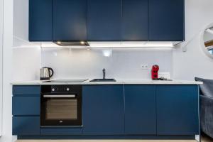 a kitchen with blue cabinets and a sink at Uroczy Apartament w Centrum Starego Miasta in Gdańsk