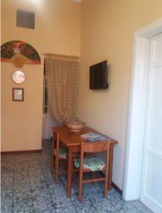 a room with a table with a chair and a television at Casa Narciso tra mare e canyon ad Avola in Avola
